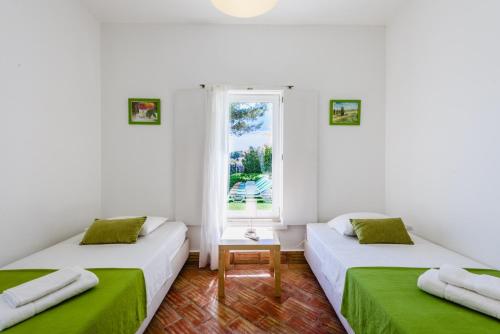two beds in a room with a window at Villa 715 - our Albufeira holiday retreat in Albufeira