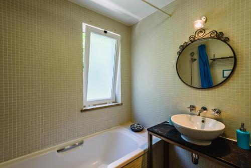 a bathroom with a sink and a tub and a mirror at Villa 715 - our Albufeira holiday retreat in Albufeira