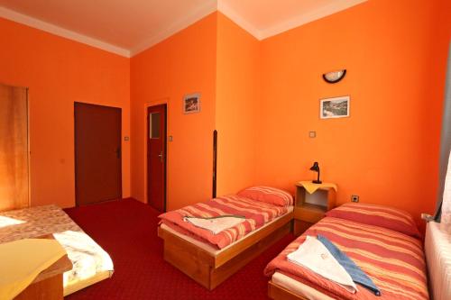 - 2 lits dans une chambre aux murs orange dans l'établissement Hotel Astoria with private skibus, à Janské Lázně