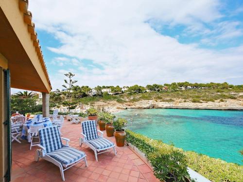 eine Terrasse mit Stühlen und einem Pool mit Wasser in der Unterkunft Holiday Home Cala Mendia Sea Views by Interhome in Porto Cristo