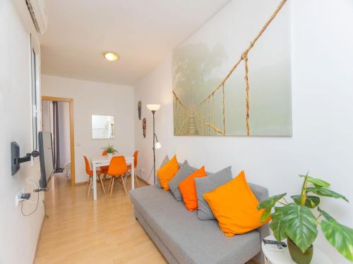 a living room with a gray couch and orange pillows at Apartment Eixample Dret Sagrada Familia by Interhome in Barcelona