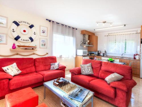 a living room with red couches and a table at Apartment Fane De Baix I by Interhome in Llança