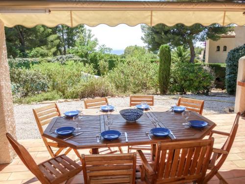 - une table en bois avec des plats bleus sur la terrasse dans l'établissement Villa Domaine Port d'Alon by Interhome, à La Madrague