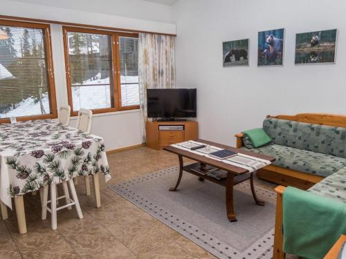 a living room with a couch and a table at Holiday Home Karhunvartijan linna b14 by Interhome in Ruka