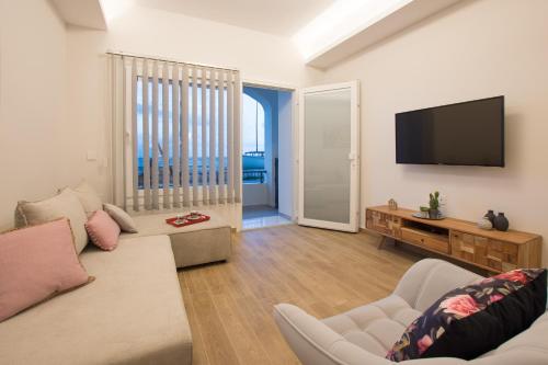 a living room with a couch and a flat screen tv at B4B Sea n' City in Zakynthos Town