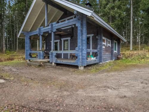 a log cabin with a porch in the woods at Holiday Home Mustikka by Interhome in Hauho