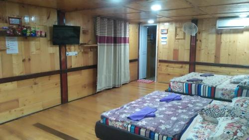Cette chambre comprend 2 lits et une télévision à écran plat. dans l'établissement Challet Tualang, à Kota Bharu
