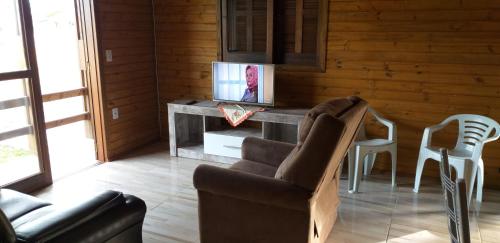 TV a/nebo společenská místnost v ubytování CHALÉS DO VÔ LÉRIO/TORRES-RS