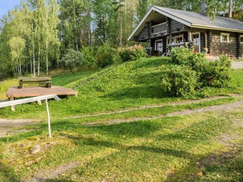 a log cabin with a picnic table in front of it at Holiday Home Savilahti by Interhome in Ahmovaara