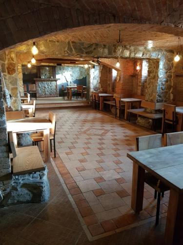 un restaurante con mesas y sillas y una pared de piedra en OperaHostel en Bydgoszcz