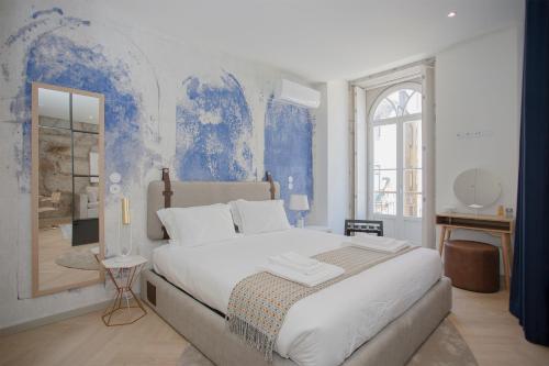 um quarto com uma cama grande e uma parede azul em Liiiving in Porto - Luxury Beachfront Apartments em Porto