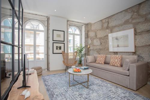 uma sala de estar com um sofá e uma mesa em Liiiving in Porto - Luxury Beachfront Apartments em Porto