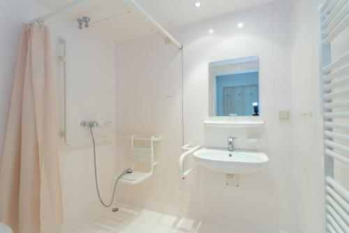 a white bathroom with a sink and a shower at Sportpark Rabenberg in Breitenbrunn