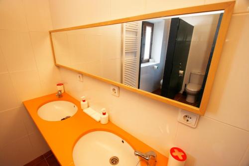 a bathroom with a sink and a mirror at Albergue de La Estación del Río Lobos in Hontoria del Pinar