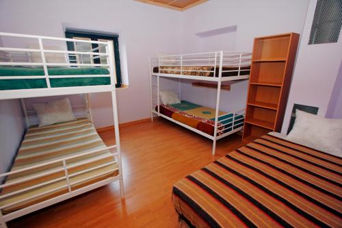a room with two bunk beds and a bed at Albergue de La Estación del Río Lobos in Hontoria del Pinar