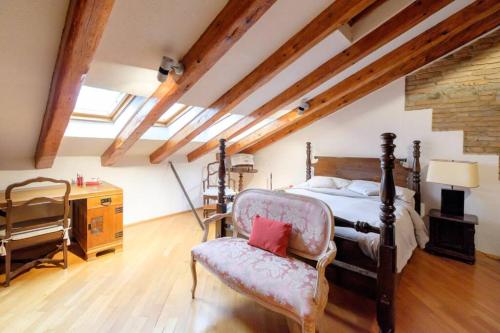 a bedroom with a bed and a chair at 6 Ponterosso - Luxury Attic in Trieste