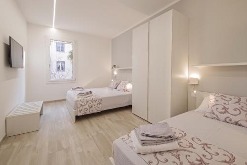 - une chambre blanche avec 2 lits et une fenêtre dans l'établissement B&BO la Frasca, à Bologne