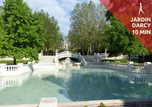 a large pool of water with a bridge in a park at SWEETHOME DIJON - Drapeau in Dijon