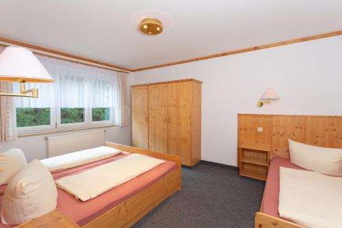 a bedroom with two beds and a window at Sportpark Rabenberg in Breitenbrunn