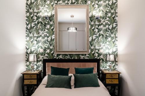 een slaapkamer met een bed met een spiegel en 2 tafels bij Sanhaus Apartments - Apartamenty Capri in Sopot