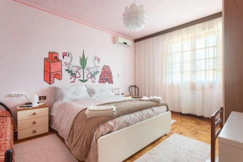 a white bedroom with a large bed and a window at B&B Il Mirto in Oristano