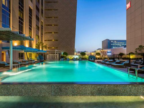 a large swimming pool in the middle of a building at Novotel Deira Creekside Dubai in Dubai