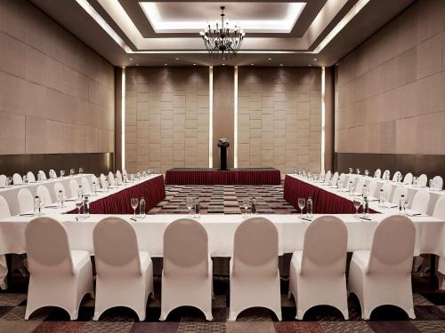 a large conference room with white tables and chairs at Pullman Hanoi in Hanoi