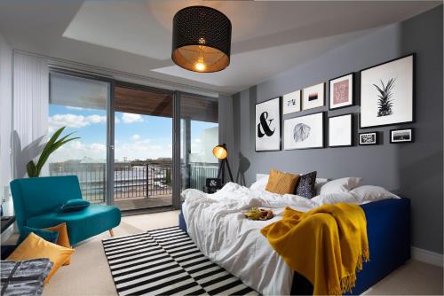 1 dormitorio con 1 cama y 1 silla azul en PENTHOUSE Plymouth Apartment- Sea View- Sleeps 7 - Private Parking - Habita Property, en Plymouth