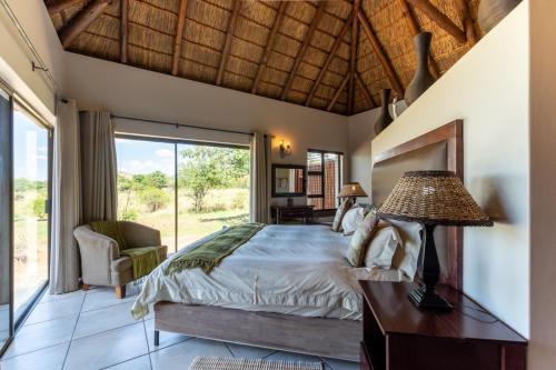 a bedroom with a bed and a large window at Zebula - HT1 - 5 Bedroom Holiday Home in Mabula
