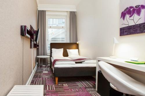 a bedroom with a white bed and white walls at Ibis Styles Stockholm Odenplan in Stockholm