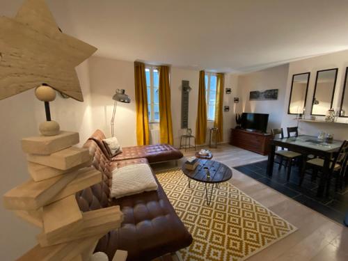 ein Wohnzimmer mit Sofa und Tisch in der Unterkunft Carpe diem in Honfleur