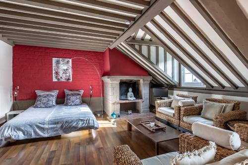 une chambre avec un lit et un mur rouge dans l'établissement Au coeur de Sainte Catherine, à Honfleur