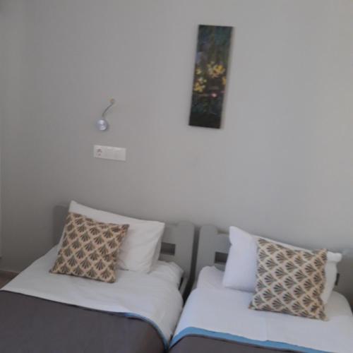 two beds sitting next to each other in a room at Aphrodite Art Hotel Aegina in Egina