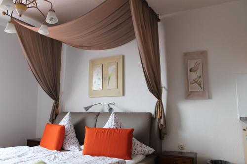 1 dormitorio con 1 cama con almohadas de color naranja en FeWo Vier Jahreszeiten Bensersiel, en Bensersiel