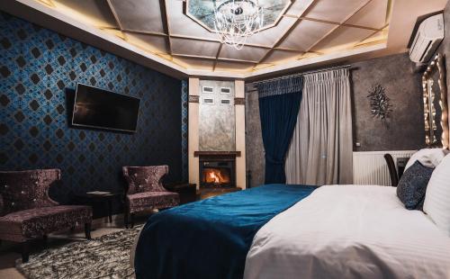 カト・ルートラキにあるEliton Hotel & Spaのベッドと暖炉付きのホテルルーム