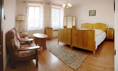 a bedroom with a bed and a table and a chair at Penzion Holland in Litomyšl