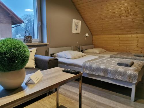 達魯旺姆芙的住宿－Ośrodek VolfCamp Kwaszenina，客房设有两张床、一张沙发和一张桌子。