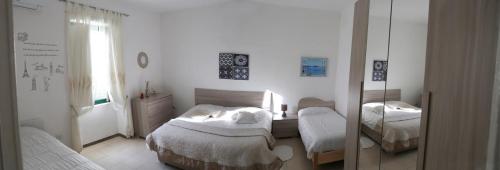 - une chambre avec 2 lits et un miroir dans l'établissement Casa Rosa appartamento con giardino, à Cetara