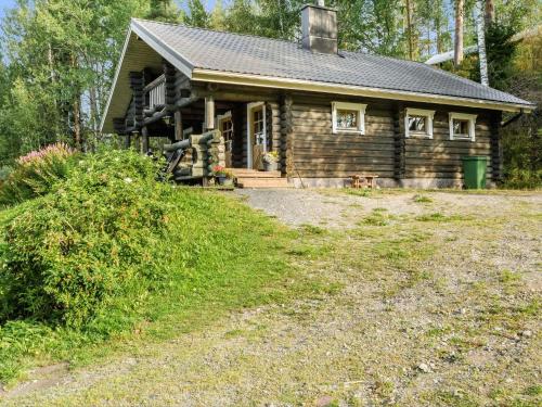 a log cabin with a dog in front of it at Holiday Home Savilahti by Interhome in Ahmovaara