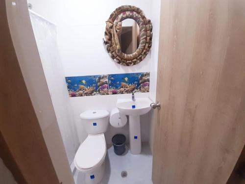 a bathroom with a toilet and a mirror on the wall at Villa Mary Hostal in Barranquilla