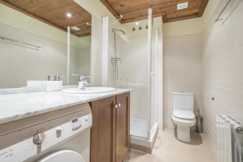 Un baño con lavabo, inodoro y ducha. en Jordana by Totiaran, en Baqueira Beret