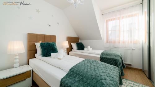 two beds in a small room with a window at Wonder Home - Domki górskie z kominkami na kameralnym osiedlu - plac zabaw na terenie kompleksu in Karpacz