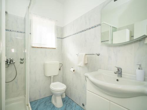 a white bathroom with a toilet and a sink at Holiday Home Mila by Interhome in Kras