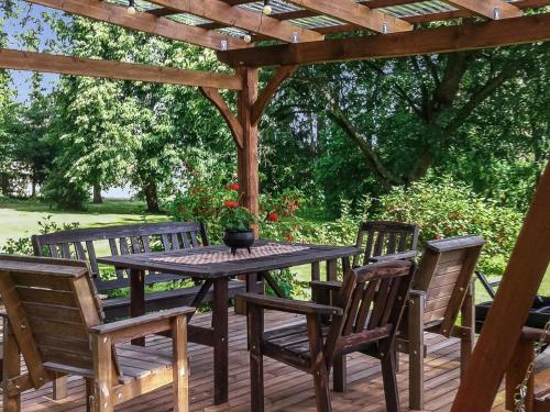 einen Tisch und Stühle unter einer hölzernen Pergola in der Unterkunft Holiday Home Villa ilmari by Interhome in Torvoila