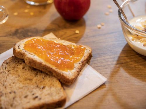 a plate with two pieces of bread with jam and an apple at hotelF1 Toulouse Aéroport in Blagnac