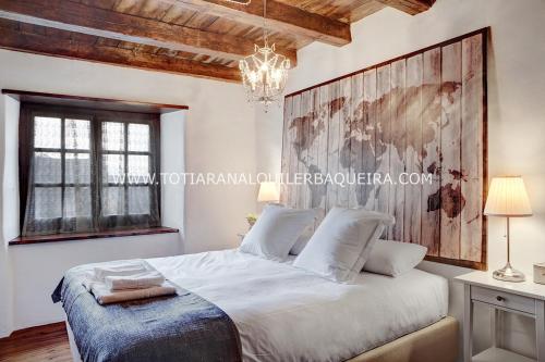 バケイラ・ベレットにあるApartamento Era Cascada By Totiaranのベッドルーム(シャンデリア付きの白い大型ベッド1台付)