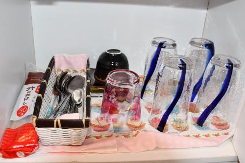 a shelf with several empty glass vases on it at Cozy house 305 free wifi a rented electric bicycle in Kyoto