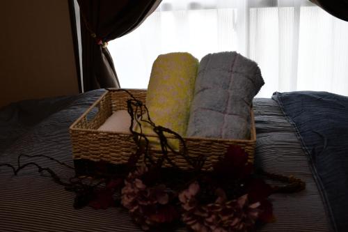a basket of towels on a bed with a window at Cozy house 305 free wifi a rented electric bicycle in Kyoto