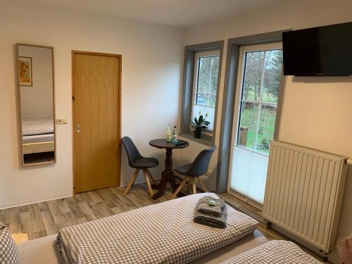 um quarto com uma cama, uma mesa e uma janela em Landgasthof Wetteraperle em Raila