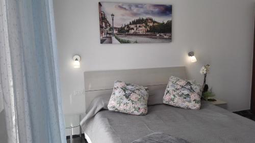 een slaapkamer met een bed met 2 kussens erop bij MinihouseLarissa diVerona in Verona